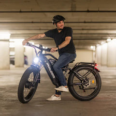 Man riding a black PHILODO Jumbo Dual Motor Electric Bike in an underground parking garage