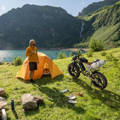 A man enjoying the bike during an camp adventure wit JANSNO X70 Adult E-Bike with 65 Nm Motor, 120 miles of range,48V/34Ah Newly Upgraded Dual Battery, 20’ x 4.0 All Terrain Wide Tyre E-Bike with Unlockable Multiple Performance Modes,CE certification - Pogo Cycles