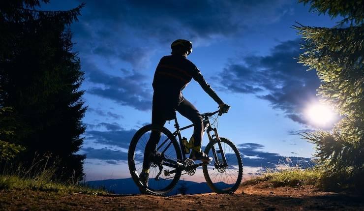 Cyclist riding an electric bike at dusk in nature, featured by Pogo Cycles e-bike store.