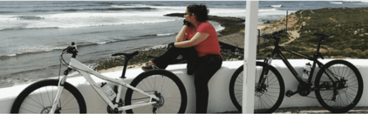 White and black electric bikes side view by the ocean on a coastal path