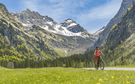 Electric road bike ridden on a mountain trail with scenic alpine landscape and blue sky